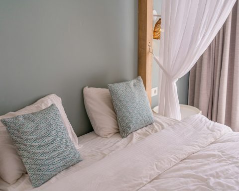 a bed with a white comforter and two pillows