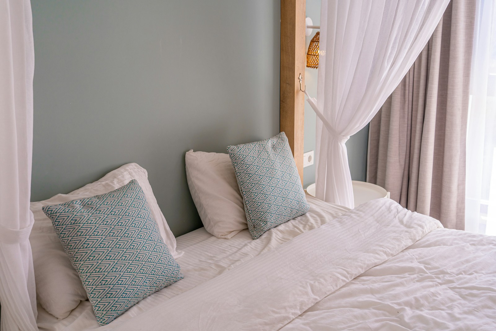 a bed with a white comforter and two pillows